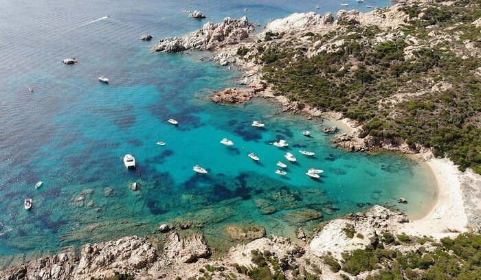 A picture of a blue-green harbor dotted with several white boats.